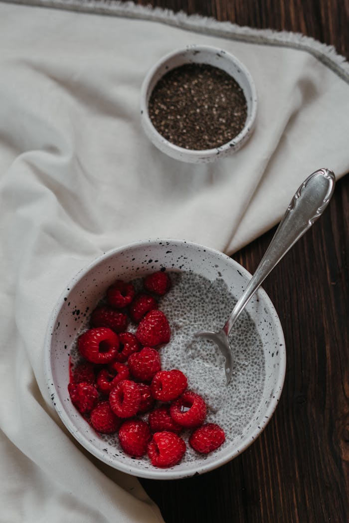 Chia pudding topped with juicy raspberries in a rustic bowl, perfect for a healthy breakfast.